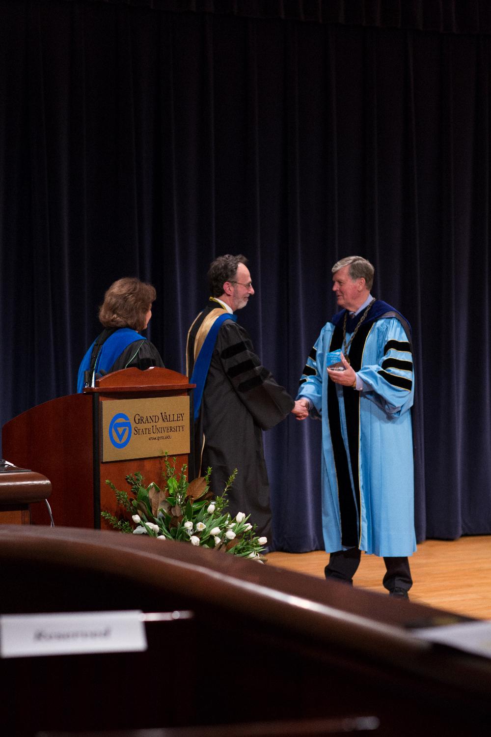 Former Provost Davis and President Emeritus Haas congratulate faculty member who is receiving an award